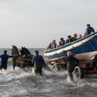 Lancering roeireddingboot Schumacher in de branding van de Noordzee